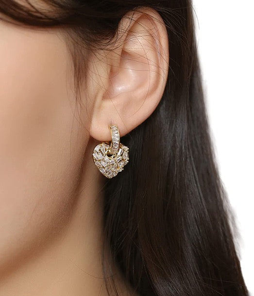 Juego de 2 piezas de aretes en forma de corazón de color dorado con circonitas cúbicas.