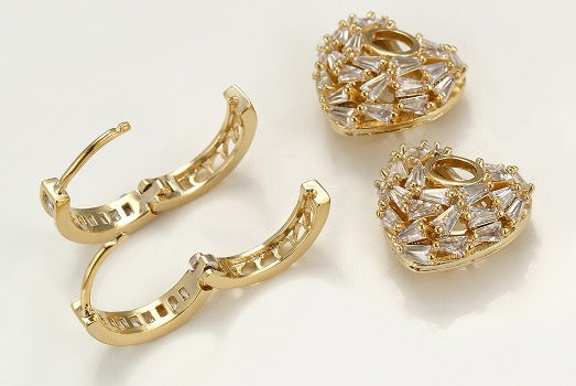 Juego de 2 piezas de aretes en forma de corazón de color dorado con circonitas cúbicas.